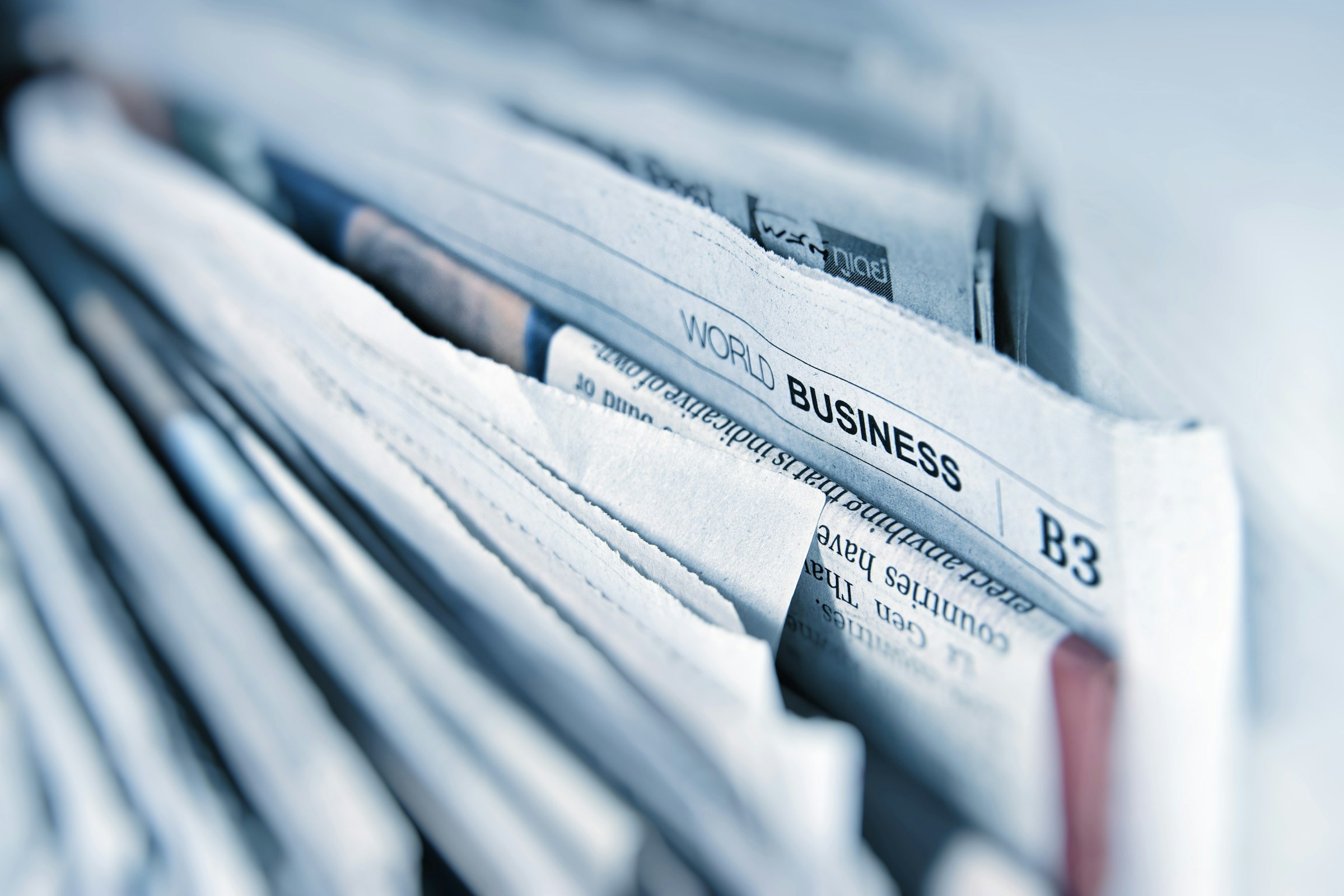 Stack of newspapers, "WORLD BUSINESS" headline